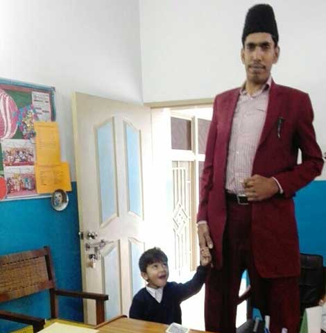 A young pupil welcomes a guest to the school office